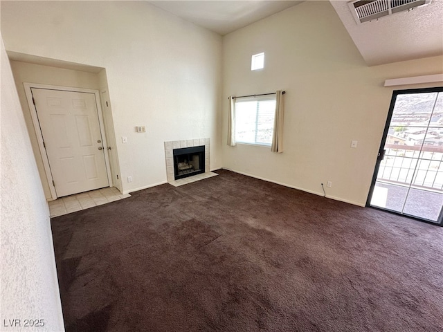 unfurnished living room featuring carpet floors, visible vents, high vaulted ceiling, and a wealth of natural light
