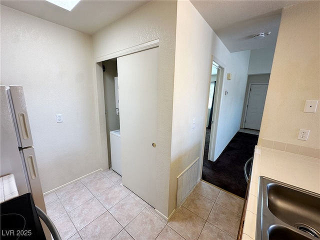 interior space with light tile patterned flooring, visible vents, and a sink