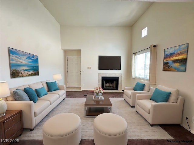 living room with baseboards, a high ceiling, and a fireplace