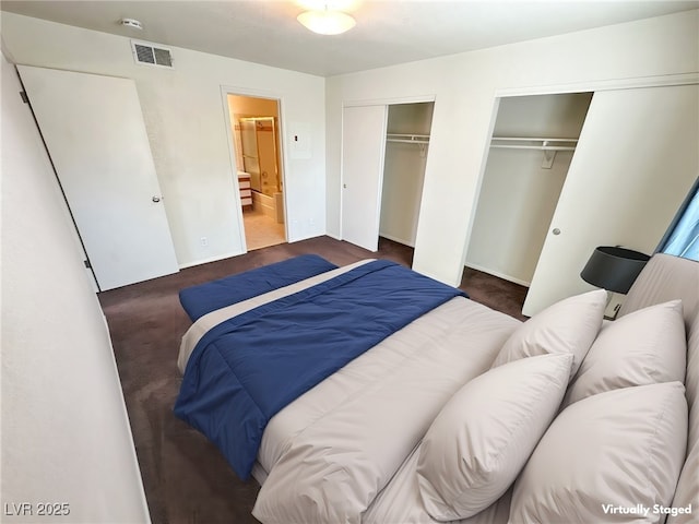 carpeted bedroom with multiple closets, visible vents, and ensuite bathroom