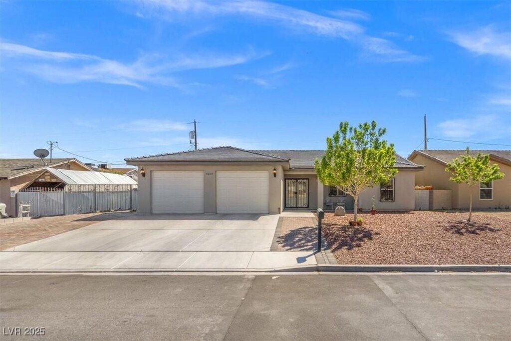 4669 E Saint Louis Ave, Las Vegas, NV 89104 - view of front of house with fence, stucco siding, an attached garage, and concrete driveway