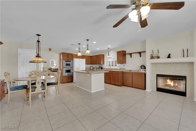 7405 Blue Sage Ct, Las Vegas, NV 89129 - kitchen with stainless steel double oven, light countertops, a ceiling fan, light tile patterned flooring, and a kitchen island