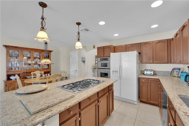 7405 Blue Sage Ct, Las Vegas, NV 89129 - kitchen featuring stainless steel appliances, light tile patterned flooring, hanging light fixtures, light stone countertops, and recessed lighting