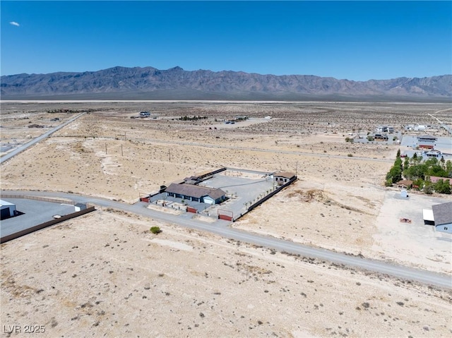 drone / aerial view featuring a mountain view, view of desert, and a rural view