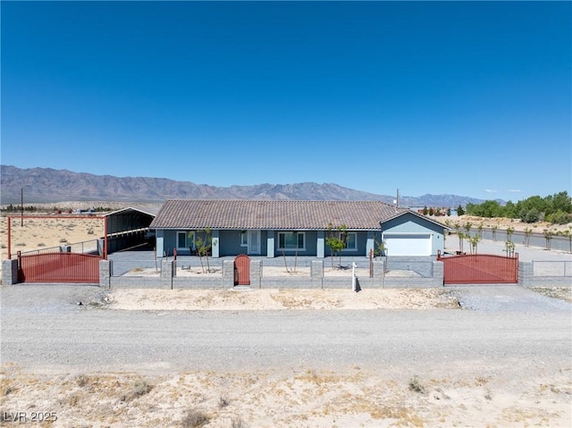 ranch-style house with a gate, a tile roof, a fenced front yard, and a mountain view