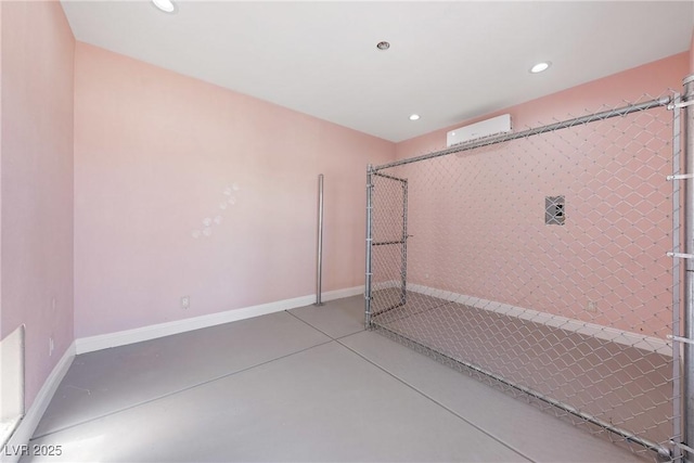 workout area featuring an AC wall unit, baseboards, and recessed lighting