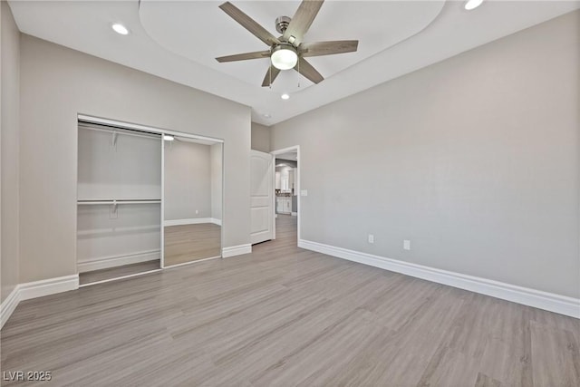 unfurnished bedroom with light wood-type flooring, a closet, and recessed lighting