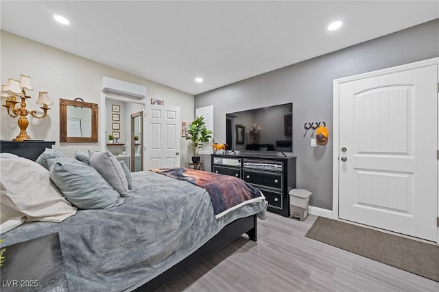 bedroom featuring light wood-style floors, baseboards, an AC wall unit, and recessed lighting