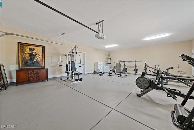 garage featuring baseboards, strapped water heater, and a garage door opener