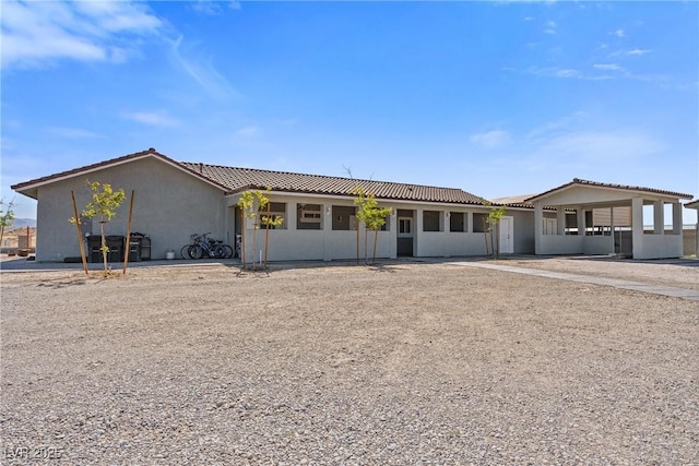 single story home featuring stucco siding and a tile roof