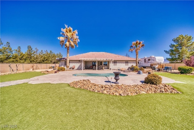 back of property with a fenced backyard, a fenced in pool, a patio area, and a yard