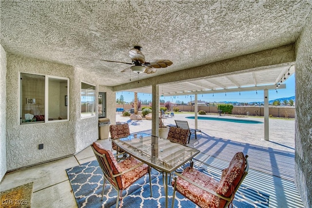 view of patio / terrace featuring a fenced backyard, a fenced in pool, ceiling fan, and outdoor dining space