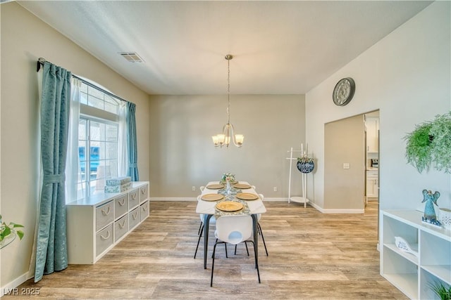 dining area with baseboards, visible vents, an inviting chandelier, and light wood-type flooring