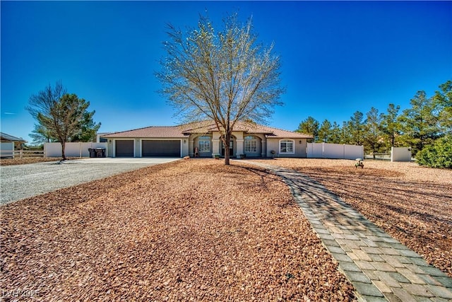 single story home featuring driveway, stucco siding, fence, and a garage