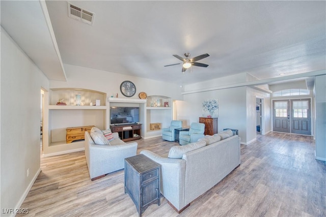 living room with light wood finished floors, baseboards, visible vents, and ceiling fan