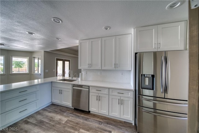 1131 China St, Pahrump, NV 89048 - kitchen with appliances with stainless steel finishes, a sink, a textured ceiling, white cabinets, and light countertops