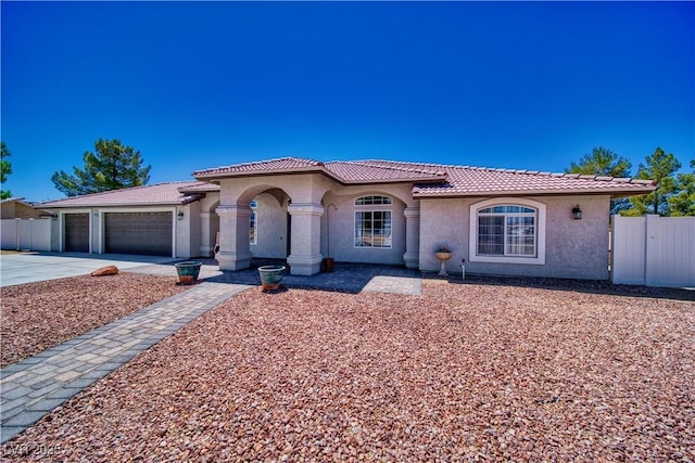 1131 China St, Pahrump, NV 89048 - mediterranean / spanish home with a tile roof, stucco siding, a garage, and driveway