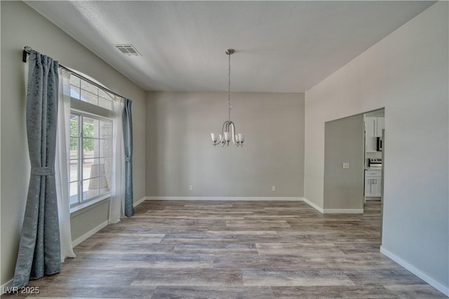 1131 China St, Pahrump, NV 89048 - unfurnished dining area with a chandelier, wood finished floors, and baseboards