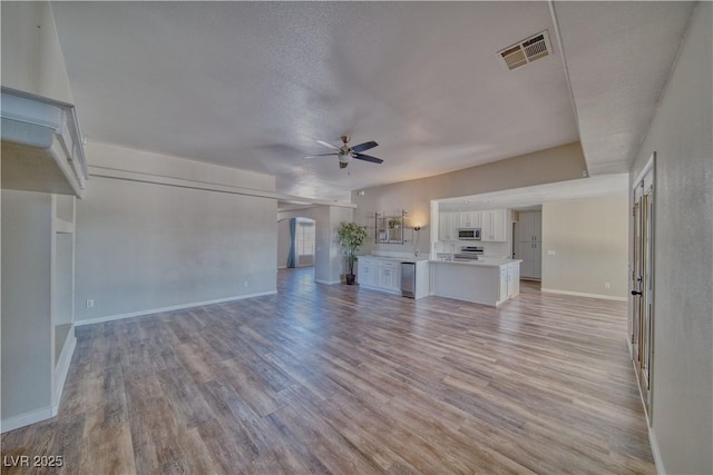 1131 China St, Pahrump, NV 89048 - unfurnished living room featuring ceiling fan, light wood finished floors, and baseboards