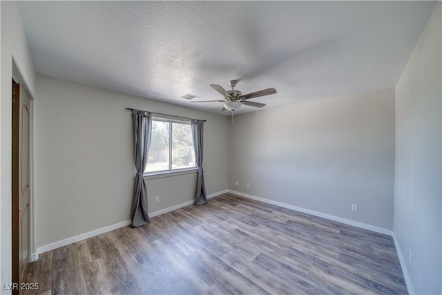 1131 China St, Pahrump, NV 89048 - spare room with wood finished floors, a ceiling fan, baseboards, and a textured ceiling