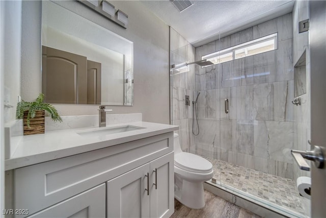 1131 China St, Pahrump, NV 89048 - full bath featuring toilet, a shower stall, wood finished floors, vanity, and a textured ceiling
