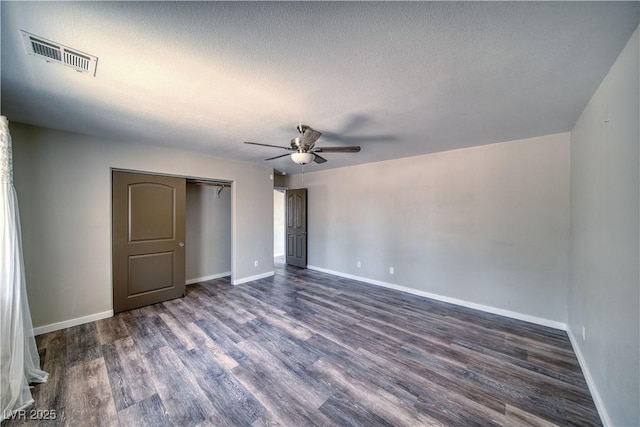 1131 China St, Pahrump, NV 89048 - unfurnished bedroom featuring dark wood-style floors, baseboards, a closet, a textured ceiling, and a ceiling fan