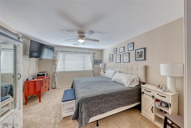 bedroom with light carpet, ceiling fan, and visible vents