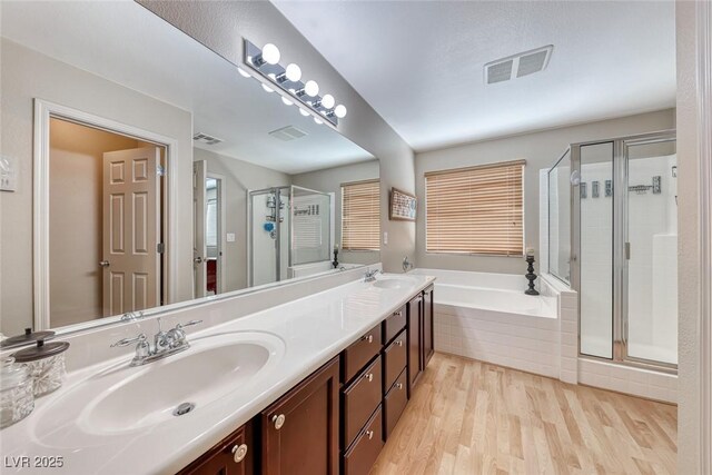 bathroom featuring a sink, visible vents, a shower stall, and a bath