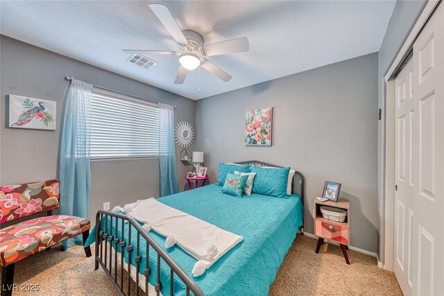 bedroom with carpet floors, visible vents, a closet, and ceiling fan