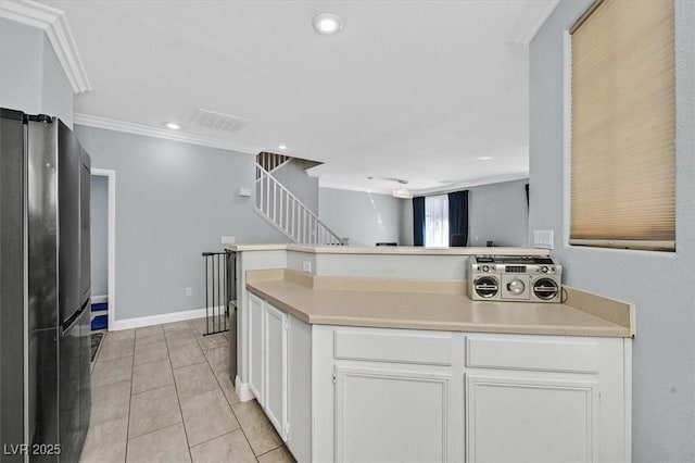 3920 Sweet Pine St Unit 102, Las Vegas, NV 89108 - kitchen featuring freestanding refrigerator, white cabinets, light countertops, crown molding, and a peninsula