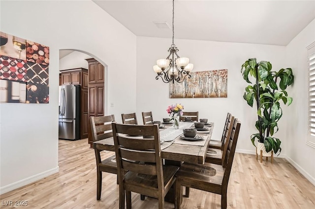 8515 Belcastro St, Las Vegas, NV 89113 - dining area with lofted ceiling, arched walkways, light wood finished floors, baseboards, and a chandelier