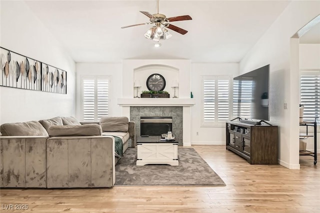 8515 Belcastro St, Las Vegas, NV 89113 - living area featuring ceiling fan, wood finished floors, a tile fireplace, lofted ceiling, and baseboards