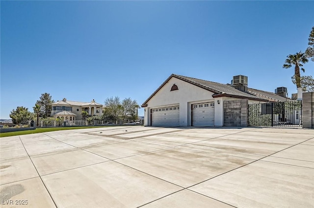 8515 Belcastro St, Las Vegas, NV 89113 - view of property exterior with stucco siding, a detached garage, and cooling unit