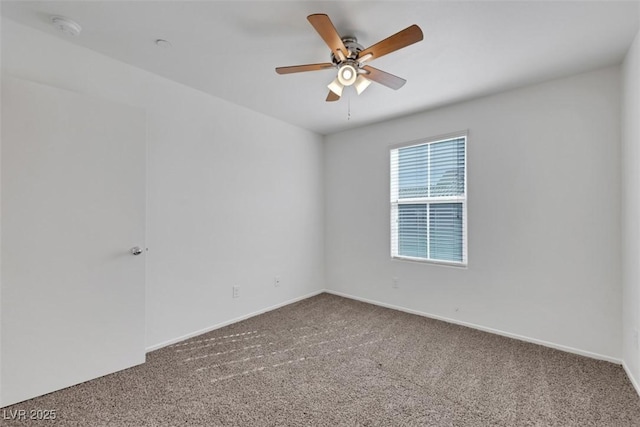 carpeted empty room with ceiling fan, baseboards, and a smoke detector