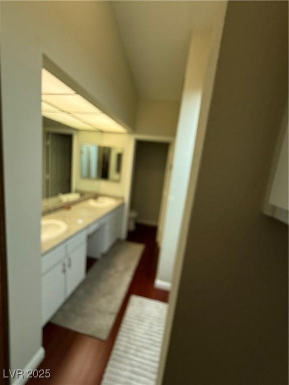 2796 Cape Hope Way, Las Vegas, NV 89121 - bathroom with wood finished floors, double vanity, lofted ceiling, and toilet