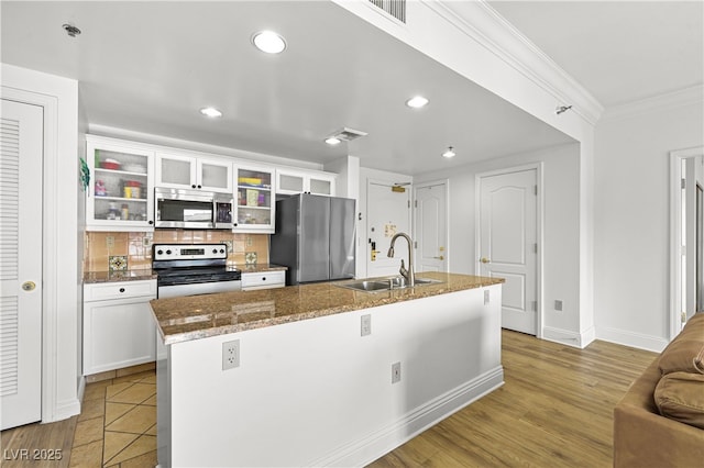 30 Strada Di Villaggio 409, Henderson, NV 89011 - kitchen with white cabinets, ornamental molding, appliances with stainless steel finishes, an island with sink, and a sink