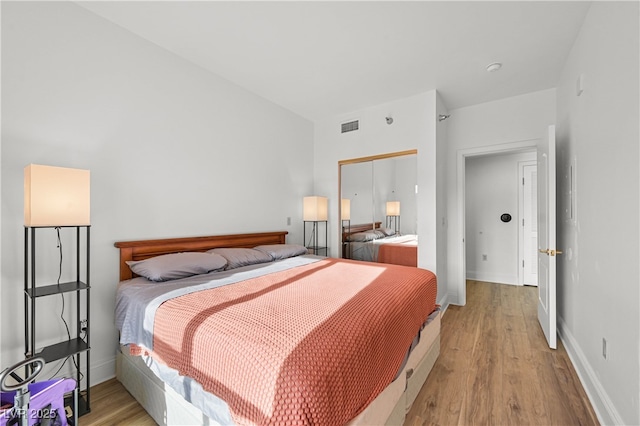30 Strada Di Villaggio 409, Henderson, NV 89011 - bedroom with baseboards, light wood finished floors, and visible vents