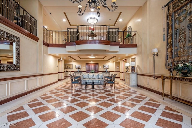30 Strada Di Villaggio 409, Henderson, NV 89011 - living area with baseboards, a decorative wall, a high ceiling, and a notable chandelier