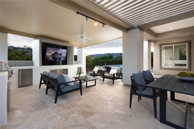 view of patio / terrace with area for grilling, ceiling fan, and an outdoor living space