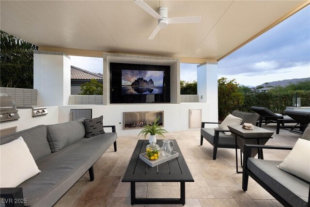 view of patio / terrace featuring an outdoor living space with a fireplace, ceiling fan, and area for grilling