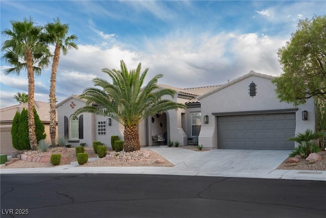mediterranean / spanish home featuring stucco siding, an attached garage, driveway, and a tile roof