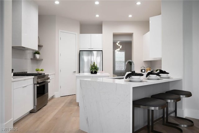 kitchen featuring stainless steel appliances, recessed lighting, white cabinetry, a peninsula, and modern cabinets