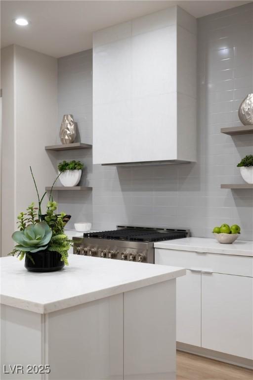 interior space featuring recessed lighting, light wood-style flooring, stove, and backsplash