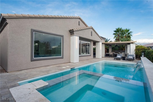 back of house with a patio, a pool with connected hot tub, and stucco siding