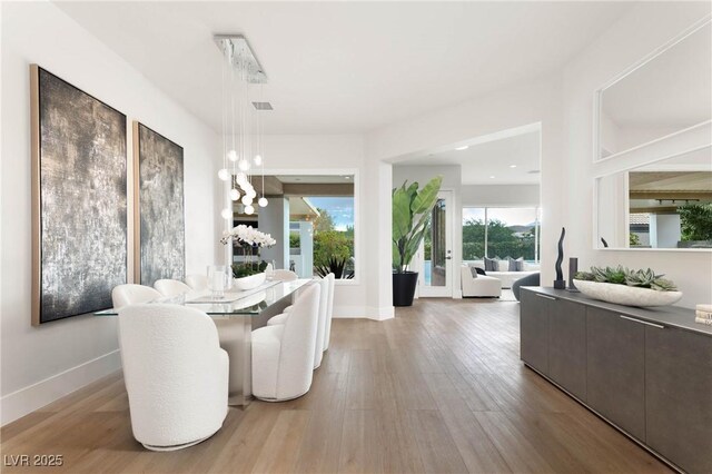 dining area with baseboards and wood finished floors