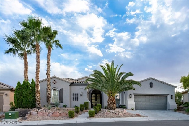 mediterranean / spanish-style house featuring a garage, stucco siding, and driveway
