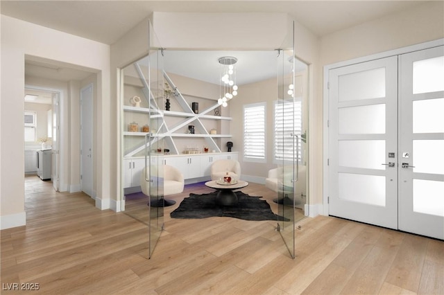 foyer featuring baseboards, french doors, and wood finished floors