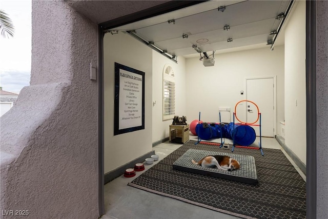 exercise room with a textured wall and baseboards