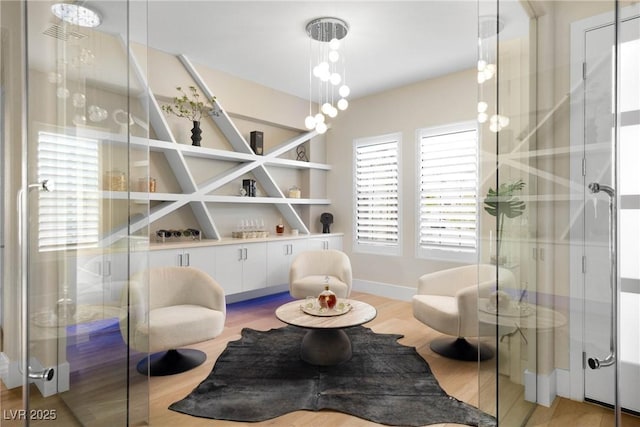 sitting room featuring baseboards and light wood-type flooring