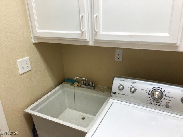 laundry area with washer / dryer, a textured wall, a sink, and cabinet space